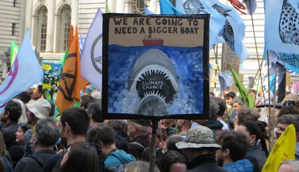 Protest march with banner reading "We are going to need a bigger boat".
